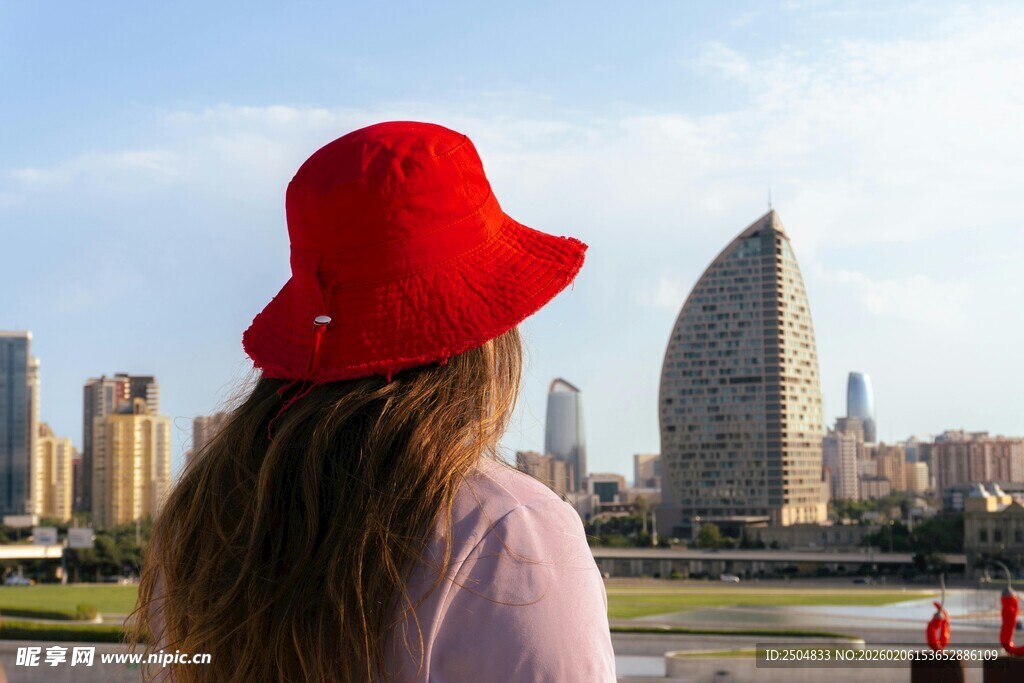 戴红帽女子眺望城市景观