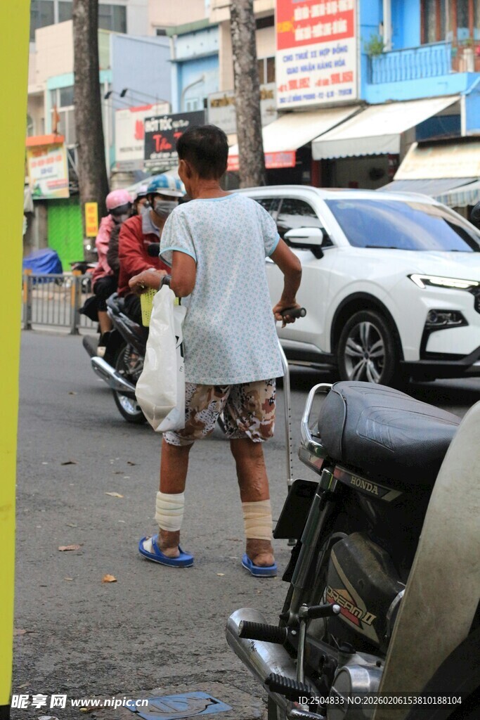 街头男子提袋站在摩托旁