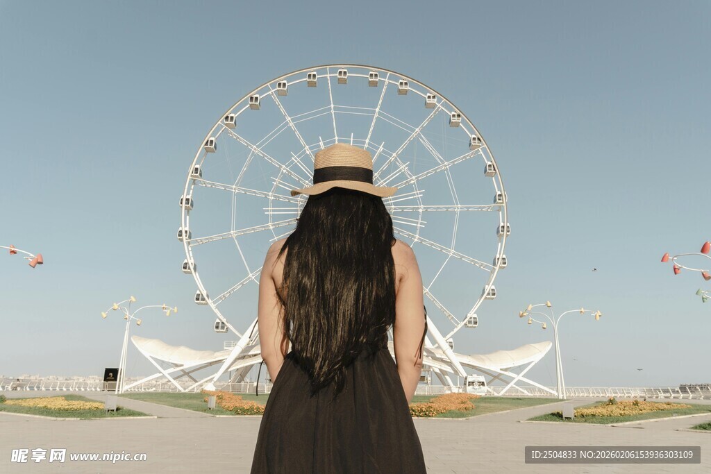 女孩背对镜头与摩天轮同框