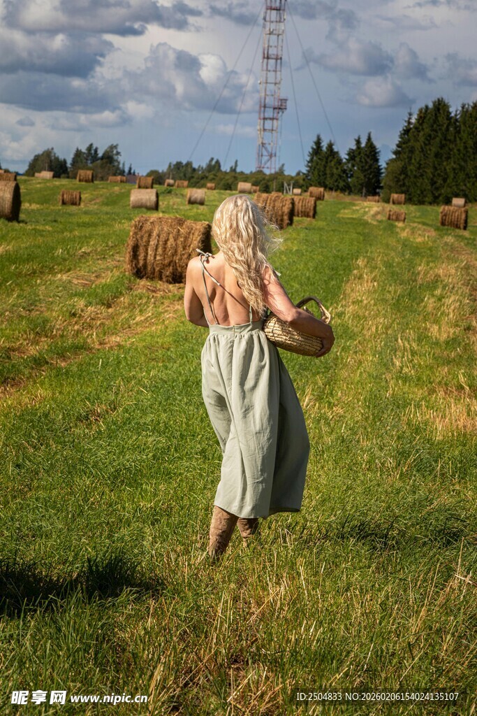 田野中提篮漫步的金发女子