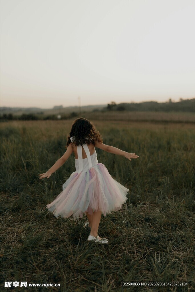 田野中起舞的白衣小女孩