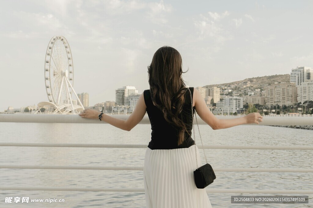 女子于河畔舒展双臂赏景