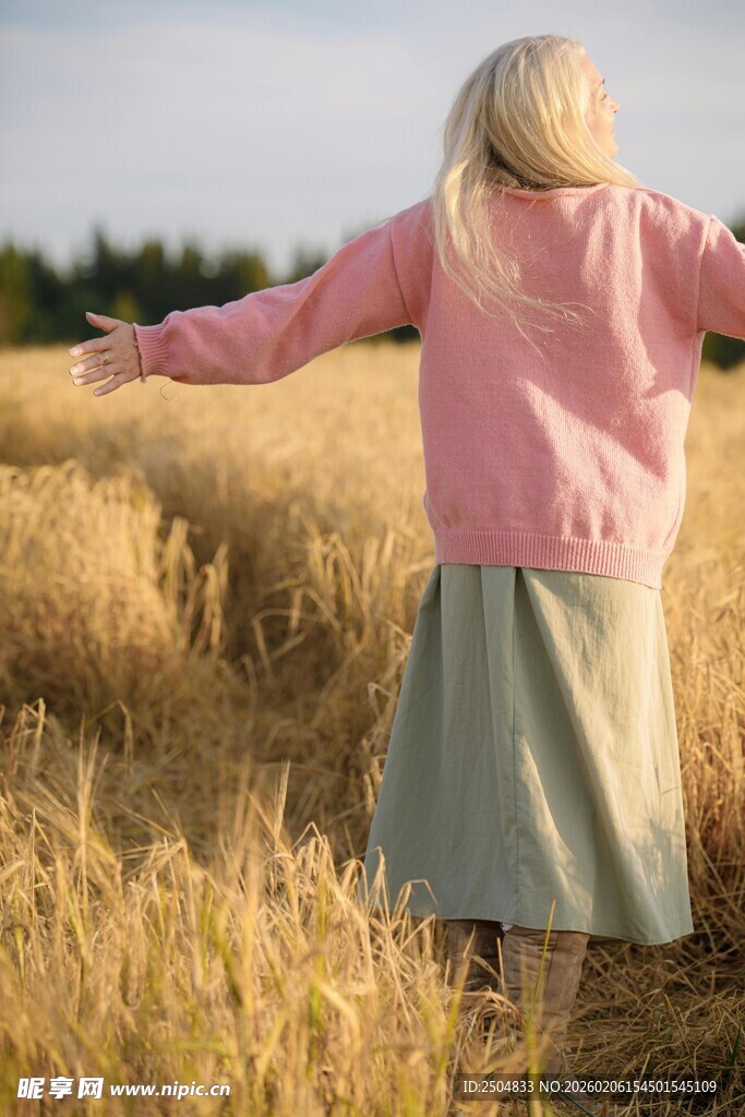 田野中伸展双臂的女子