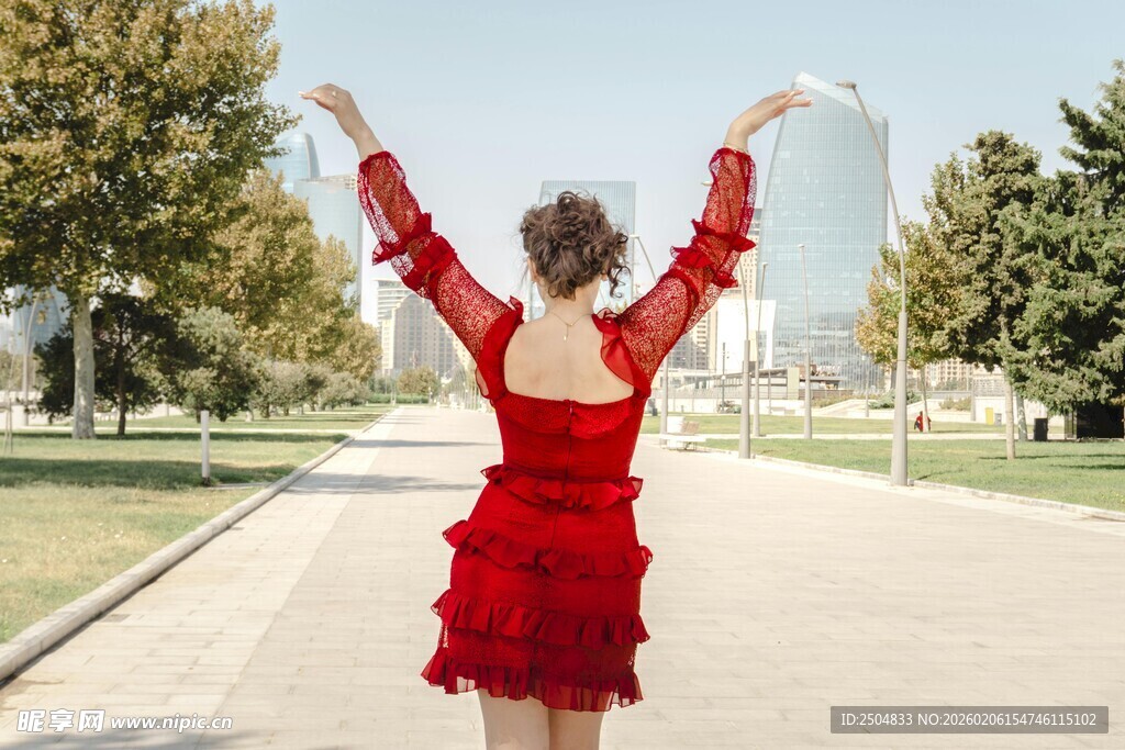 红衣女子于户外舒展双臂