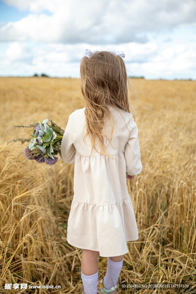 田野中持花小女孩背影