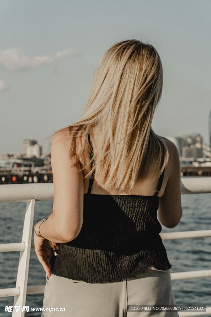 金发女子倚栏赏景