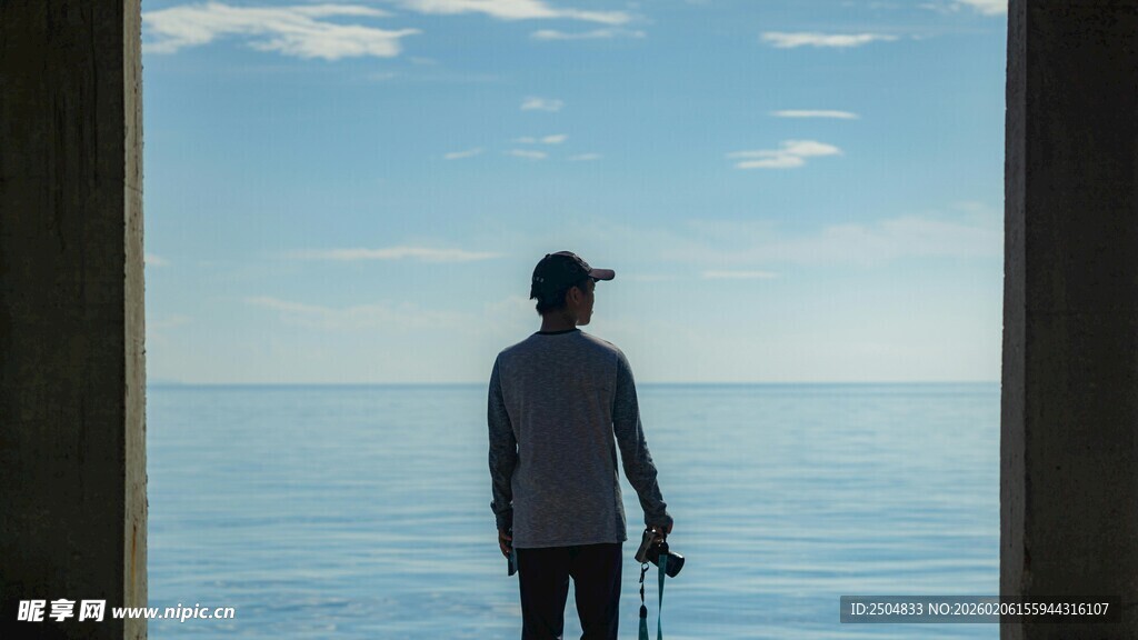 男子海边持物独自眺望