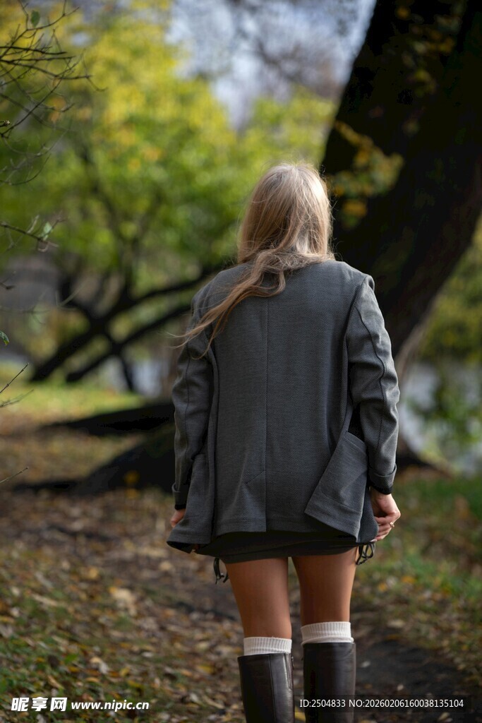 女孩漫步于秋日林间小道
