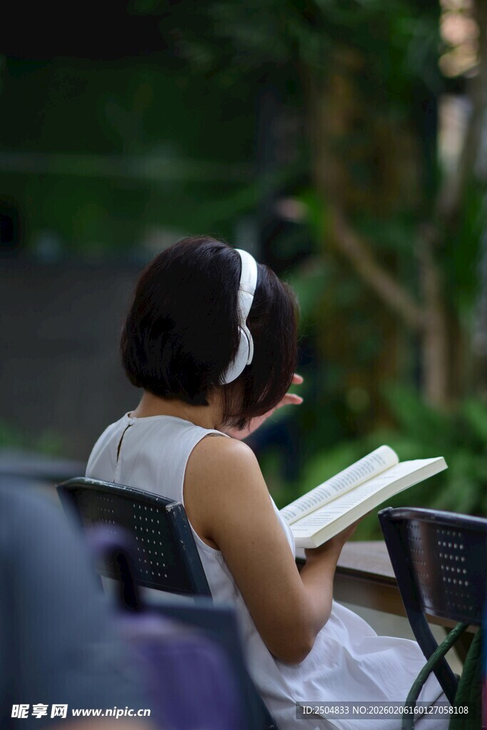 户外戴耳机阅读的女士