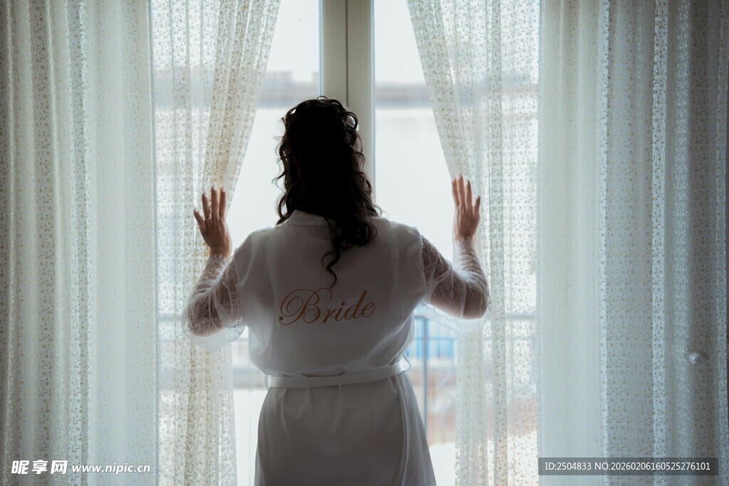 窗边女子身着睡袍望向外