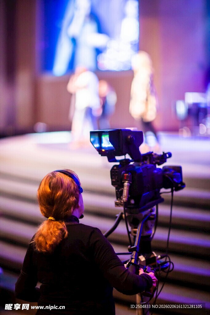 摄像师专注拍摄舞台场景
