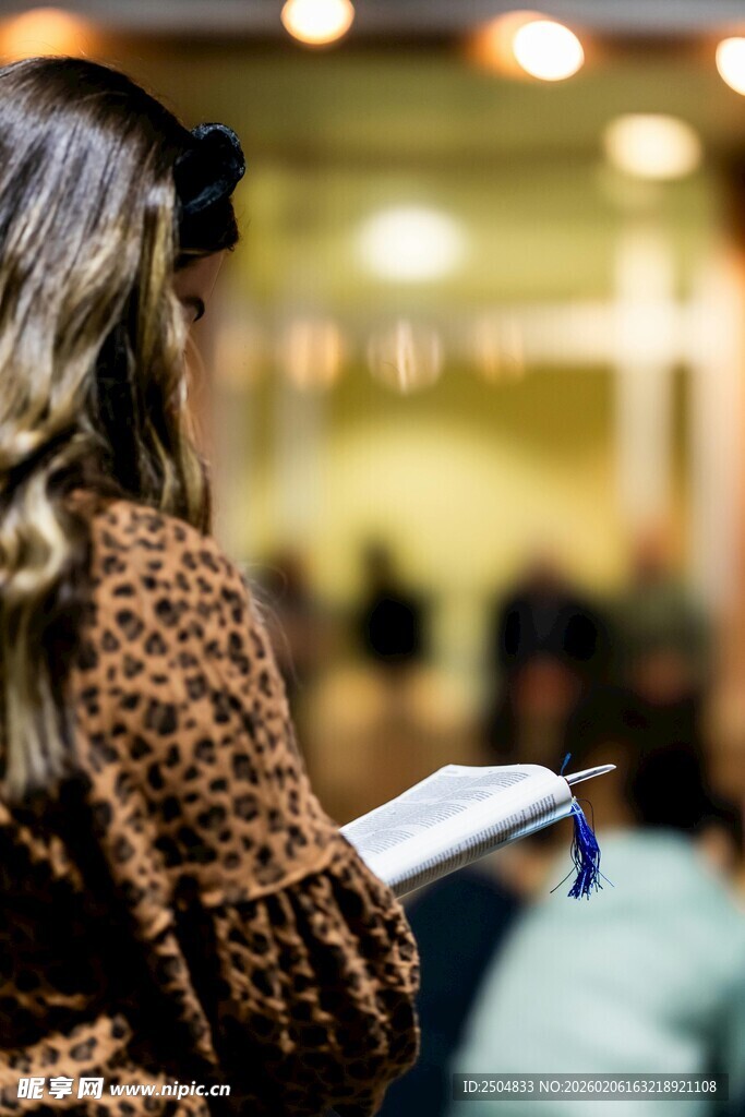 女子手持书本于室内场景