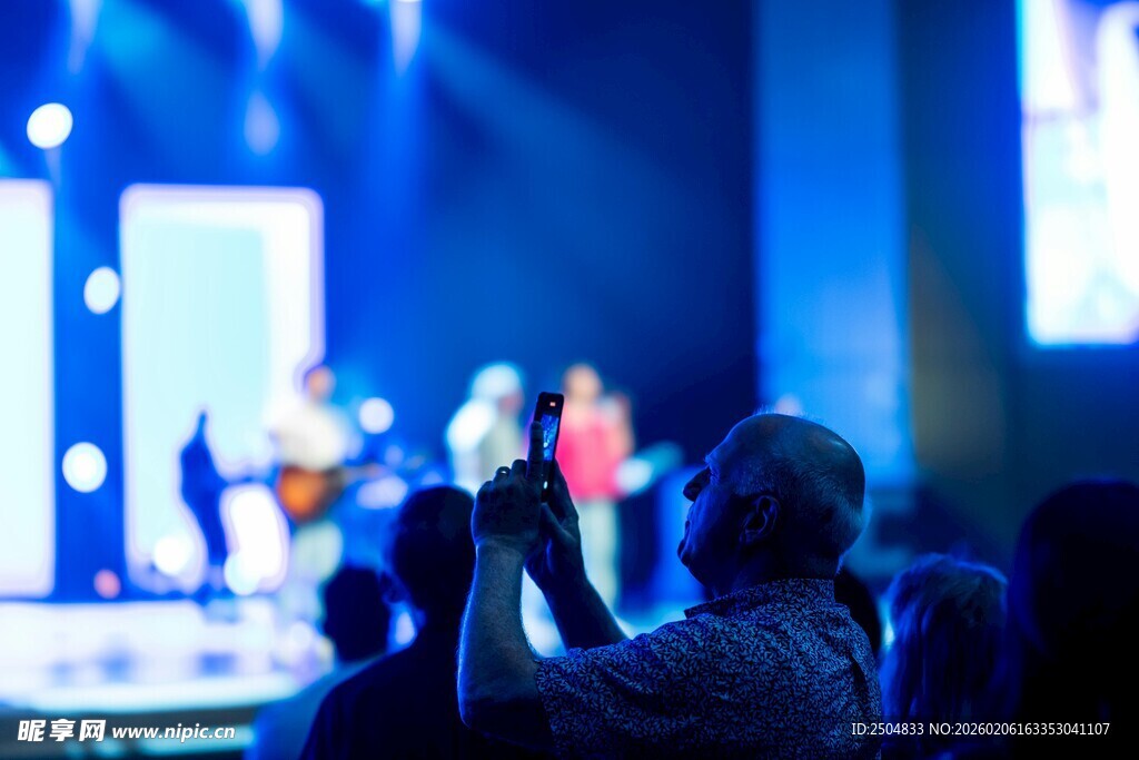 观众舞台前专注拍照瞬间