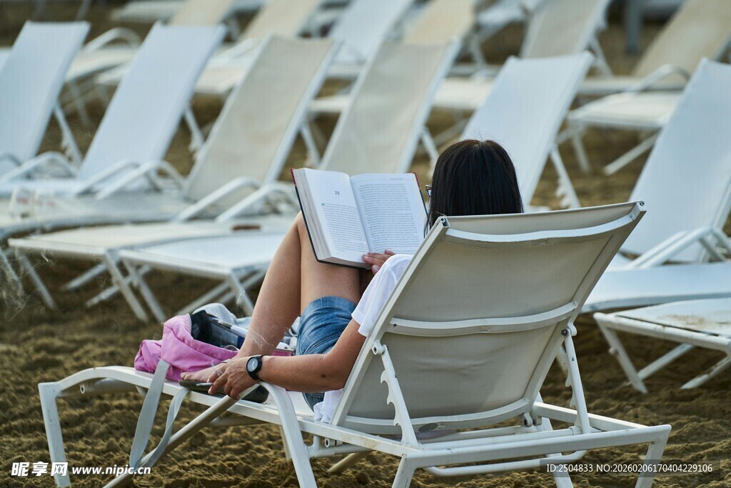 沙滩椅上阅读的休闲女子
