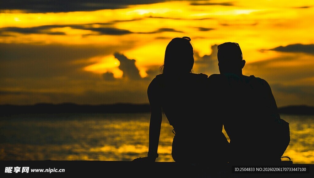 夕阳下海边的情侣剪影