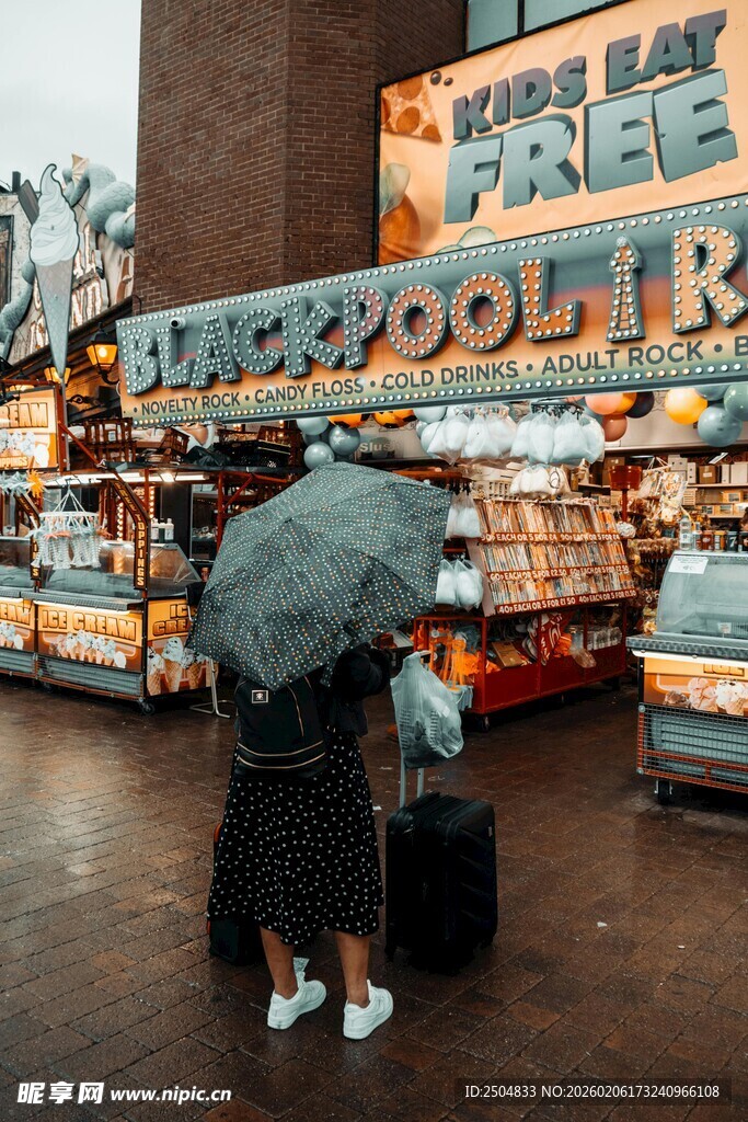 雨中书店前撑伞的行人