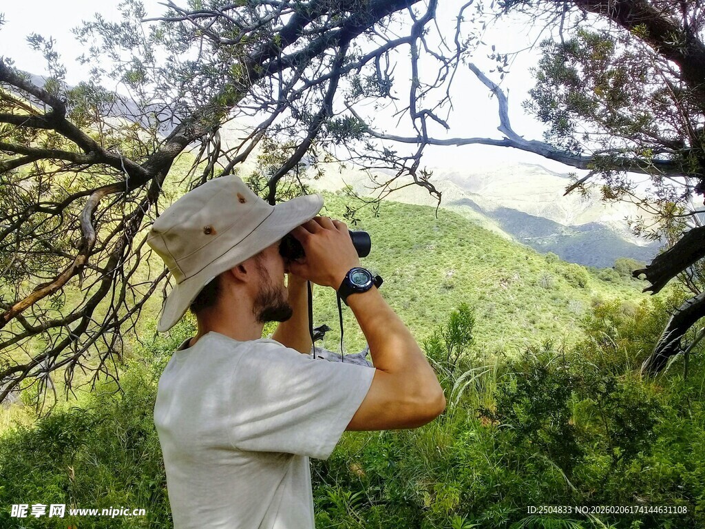 男子林间用望远镜观察景色