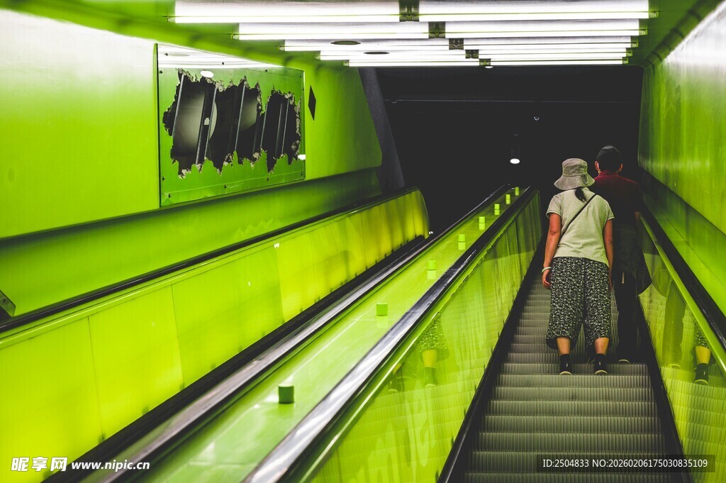 绿色自动扶梯上的行人