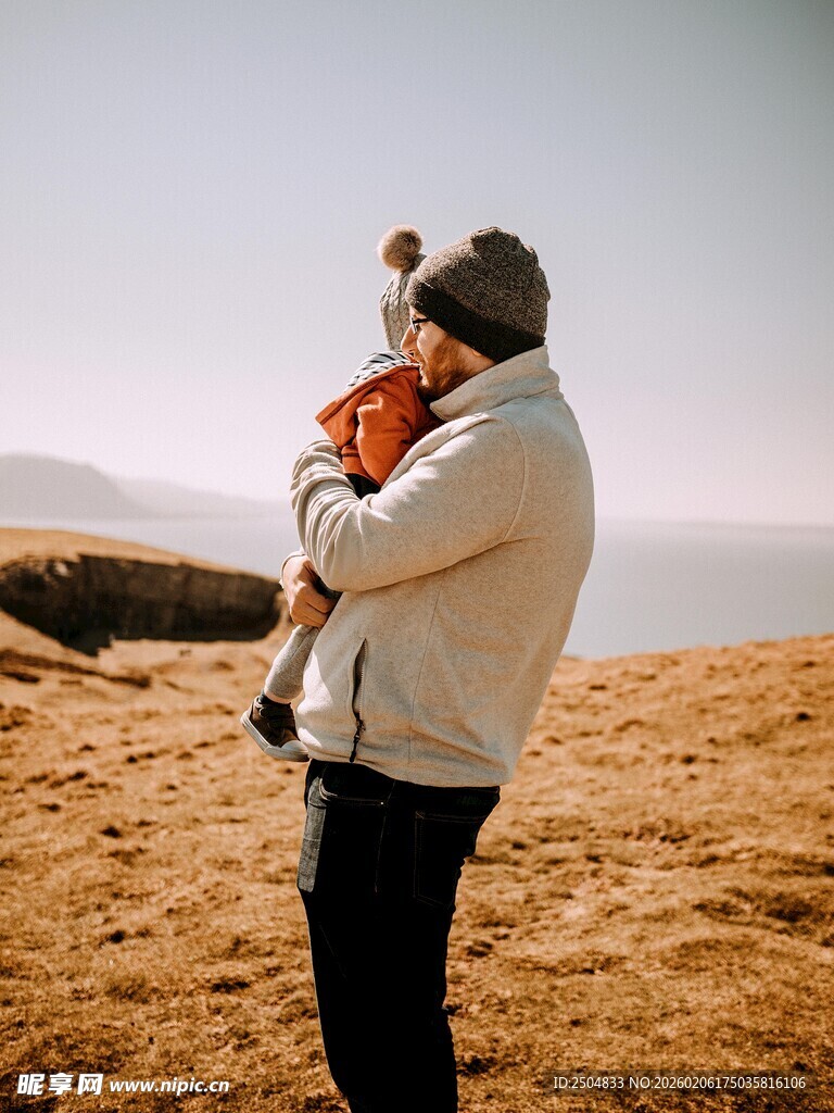 父亲抱孩子于旷野赏景