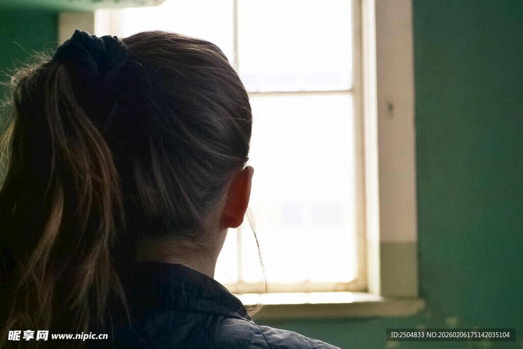 背对镜头望向窗外的女子