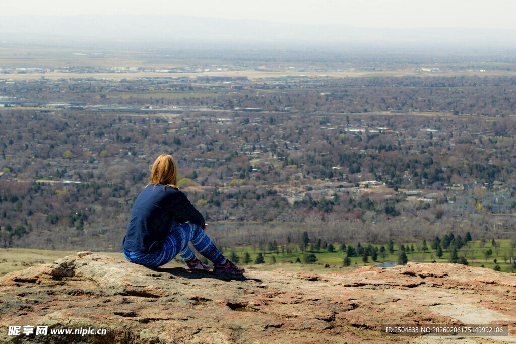 女子山顶俯瞰远方城市