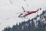 雪山中飞行的红白直升机