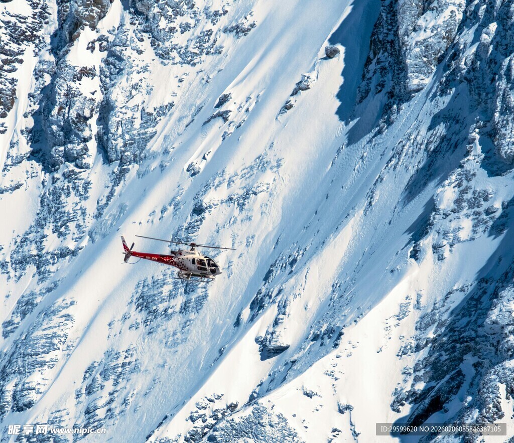 雪山中飞行的红色直升机