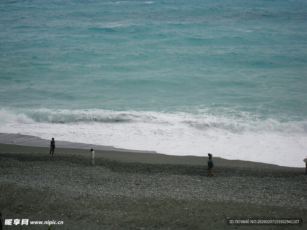 海边漫步的人群与海浪