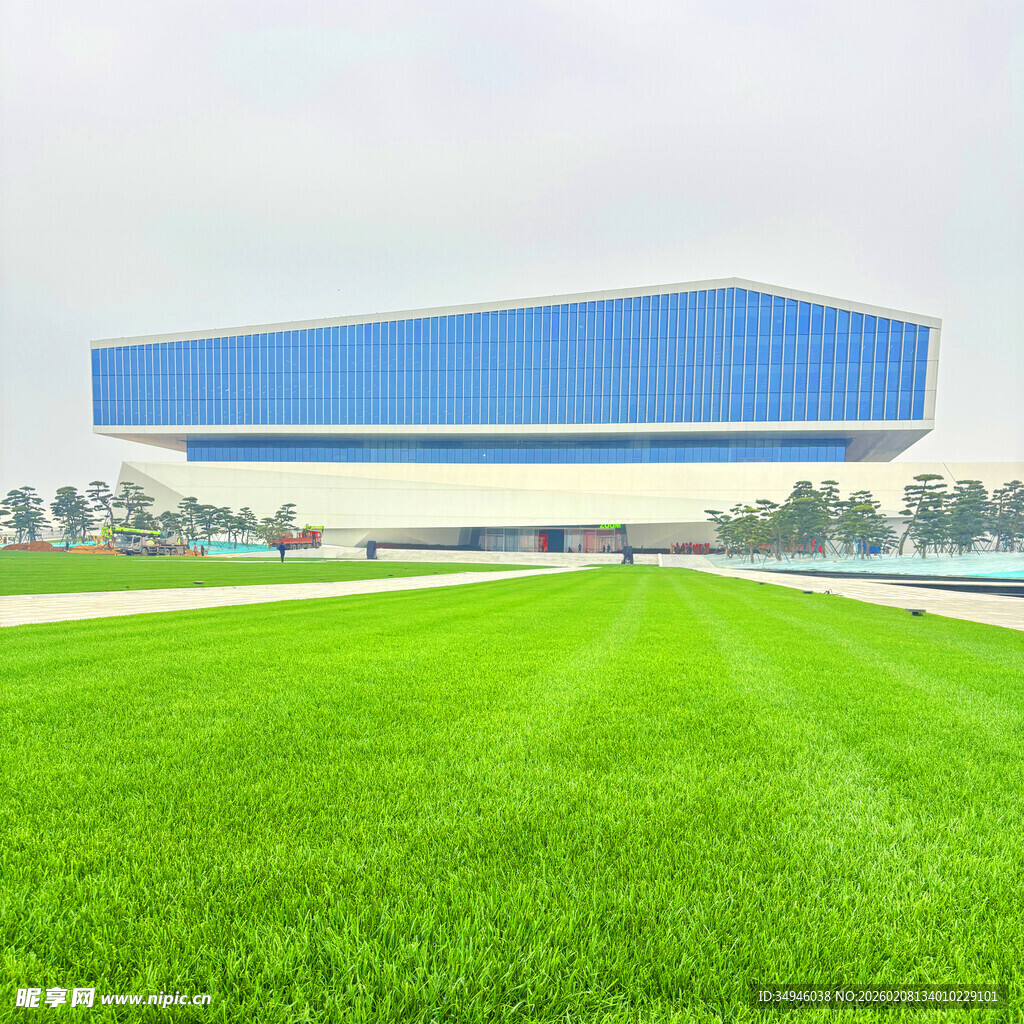 蓝顶厂房前的大片绿草地