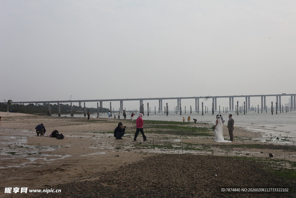 湛江江边行人与远处桥梁景观