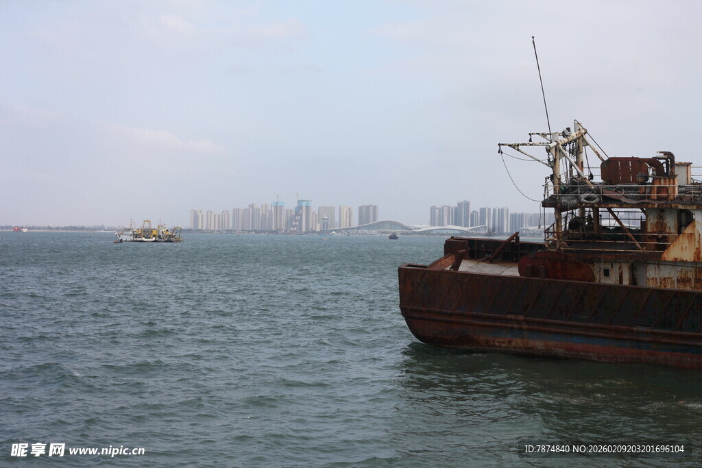 海上旧船与远处城市景观