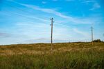 草原上的电线杆与蓝天