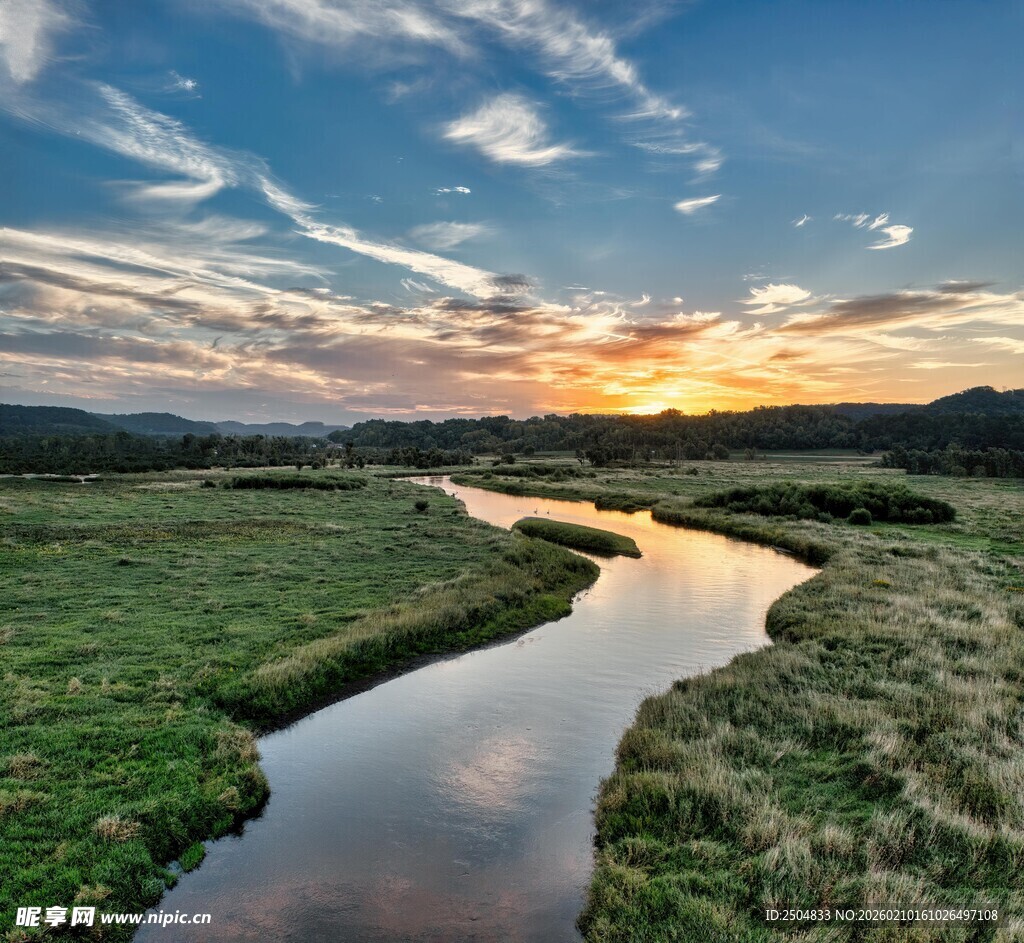 夕阳下蜿蜒于草地的小河