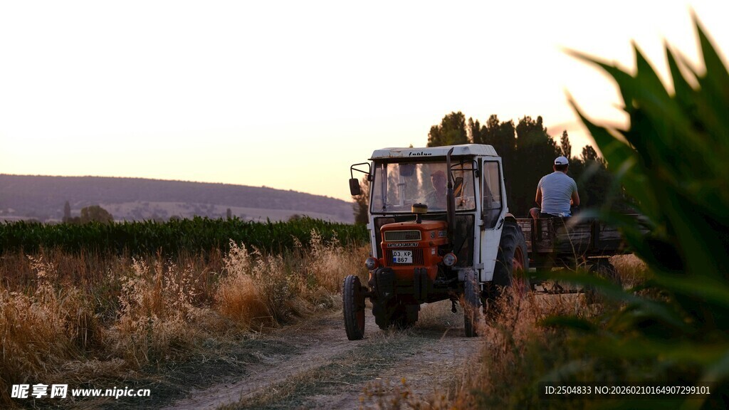 夕阳下的农田拖 机劳作