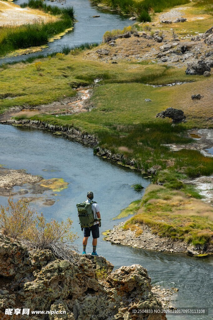 男子河畔岩石上眺望风景
