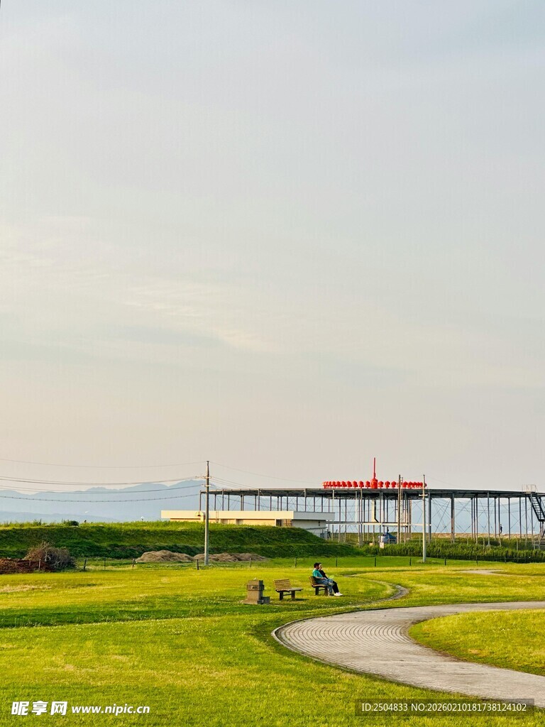 海滨草地与远处栈桥风景