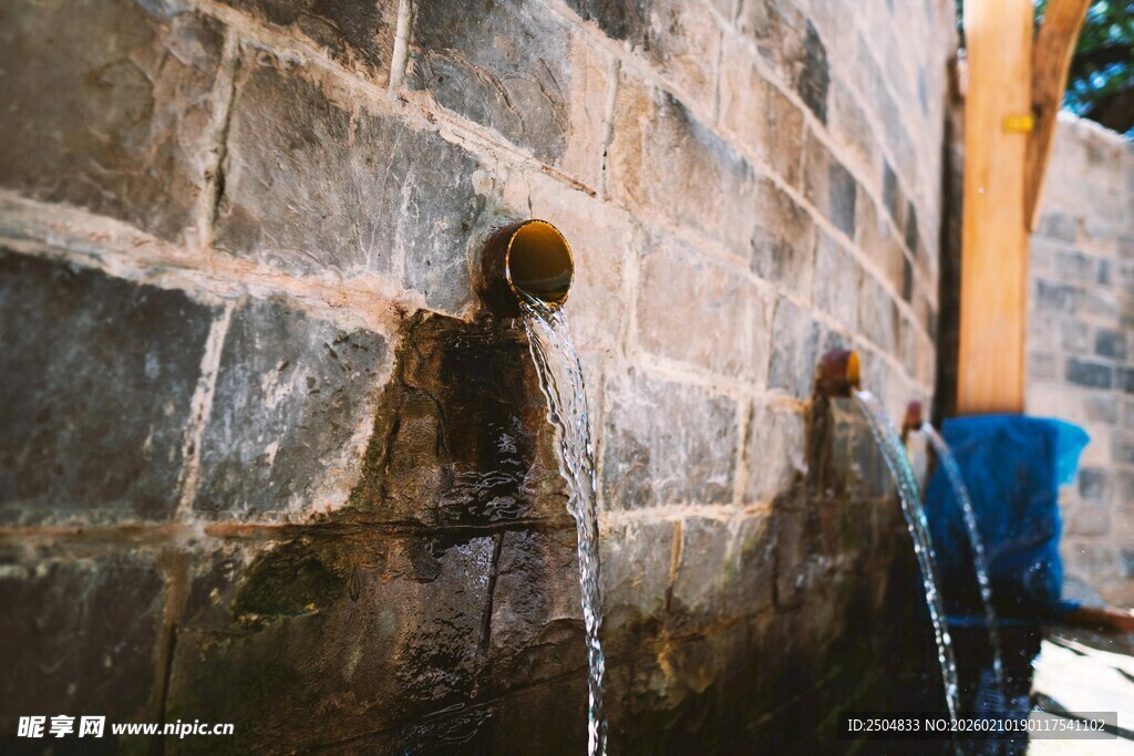 儿童在石墙旁玩水场景