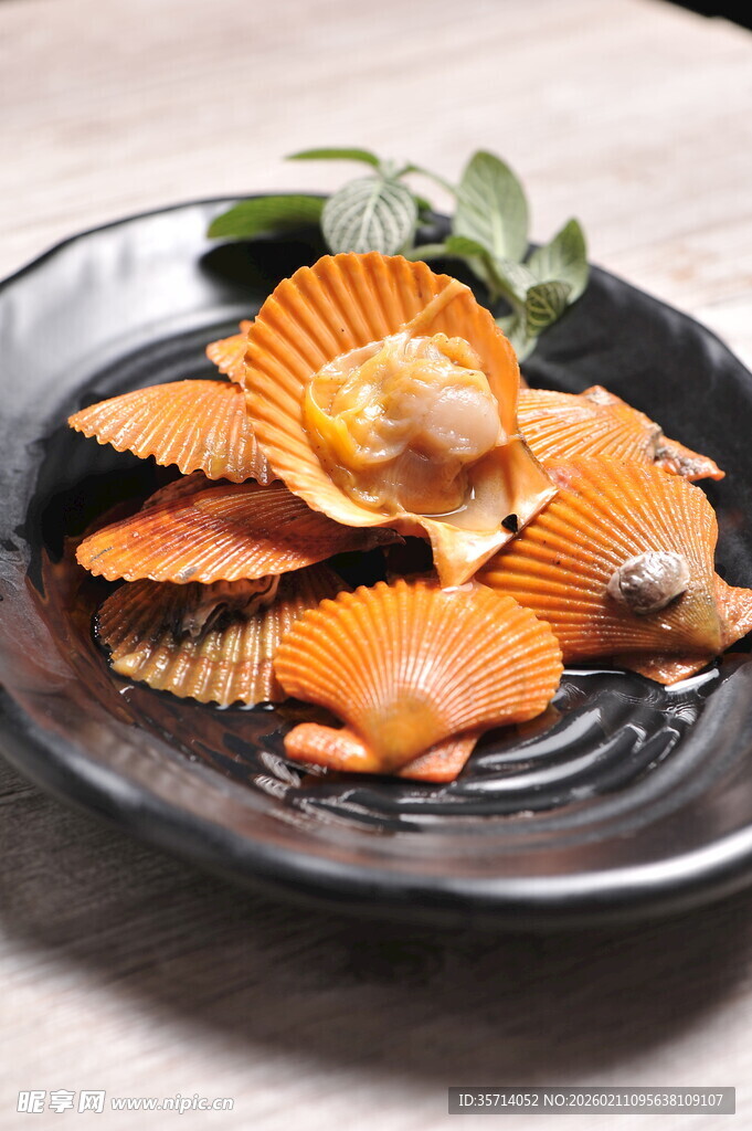 美味扇贝摆于黑色盘中
