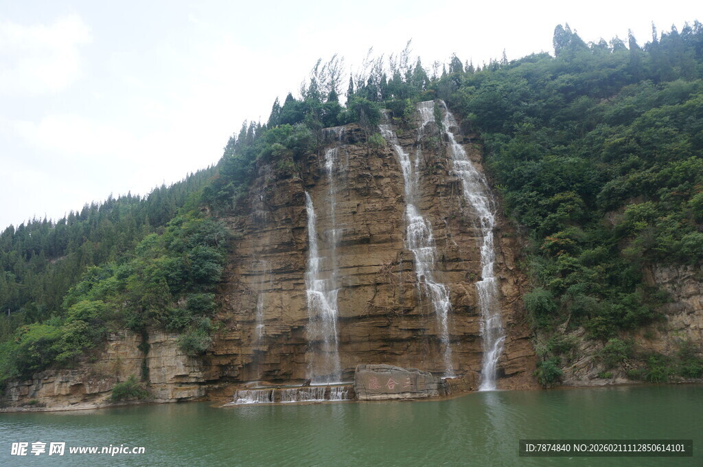 山间瀑布倾泻于绿水之上