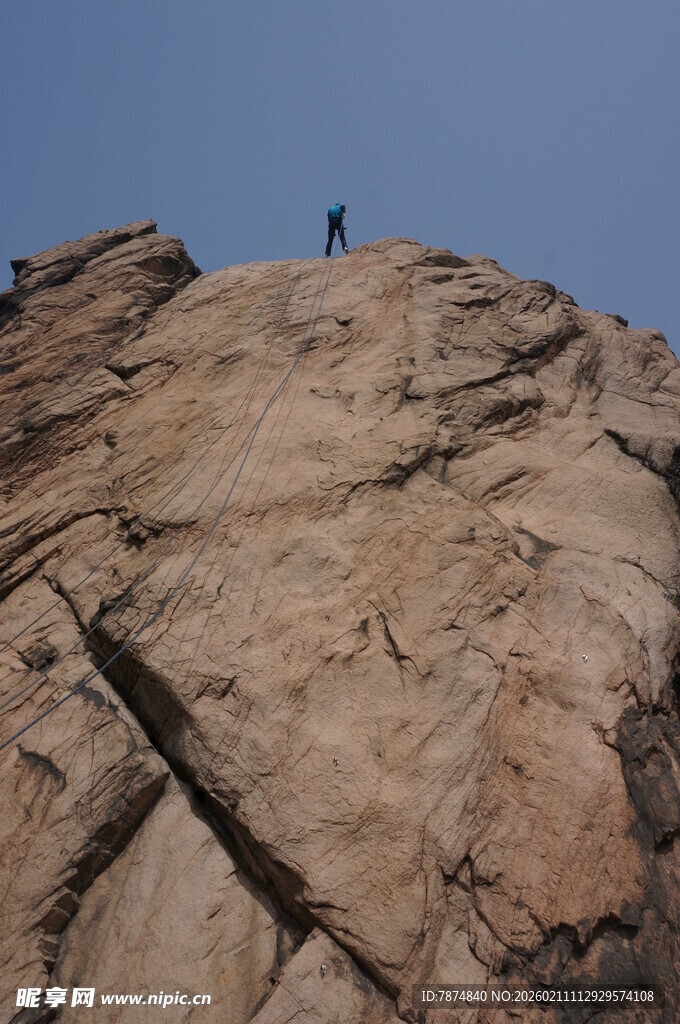 攀登者立于陡峭岩石之巅