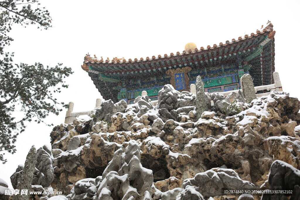 雪覆假山旁的中式古建筑