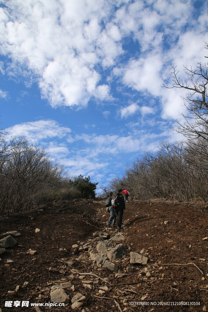 徒步者在山间的泥泞小道上