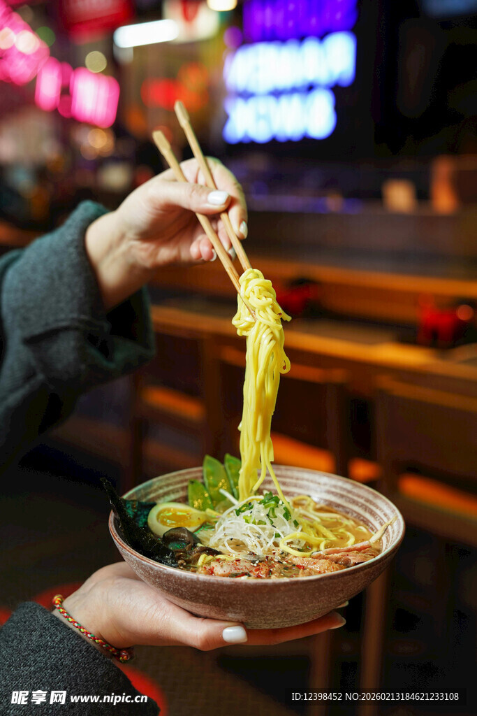 手持筷子夹起拉面