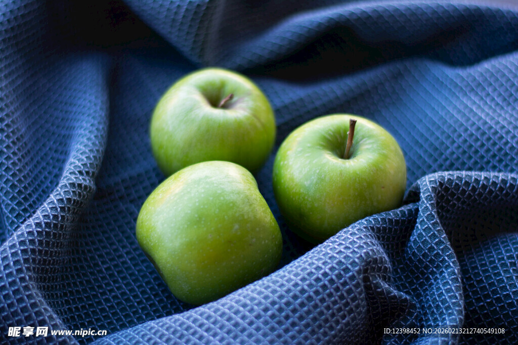 青苹果置于蓝色布上