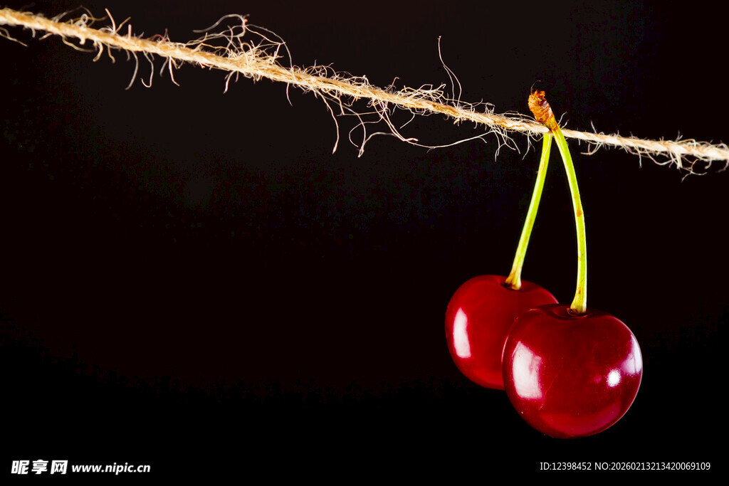 双颗红樱桃悬挂于绳上