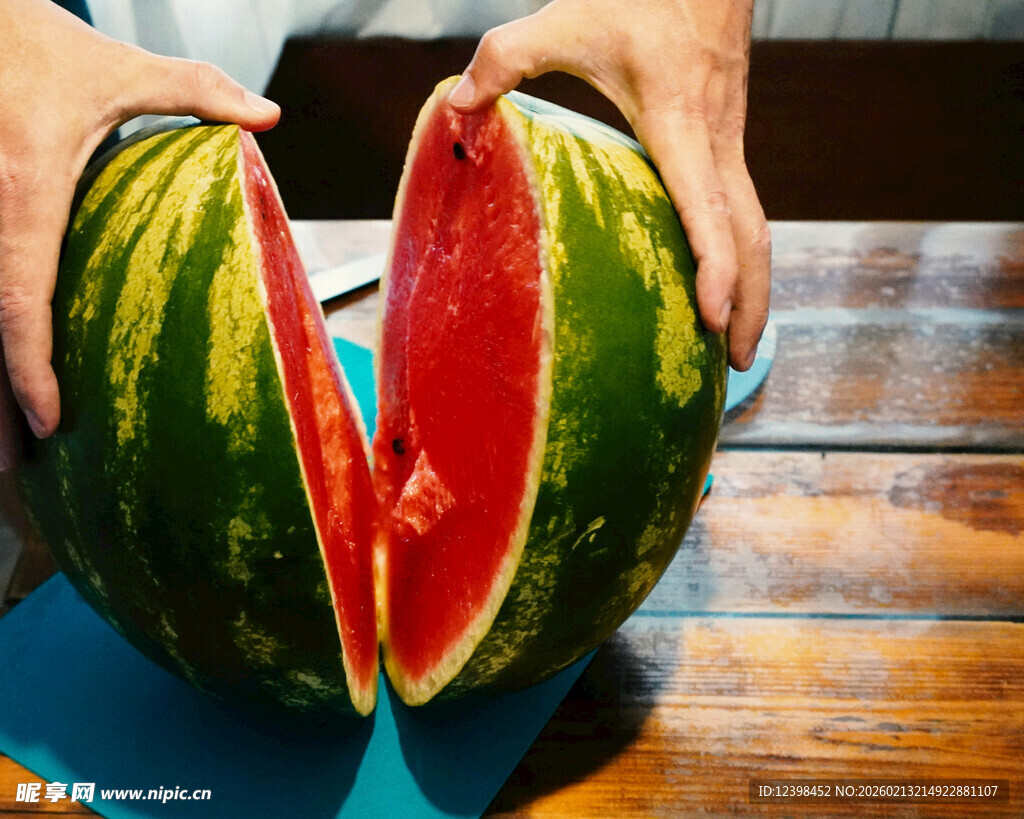 双手掰开的鲜红多汁西瓜