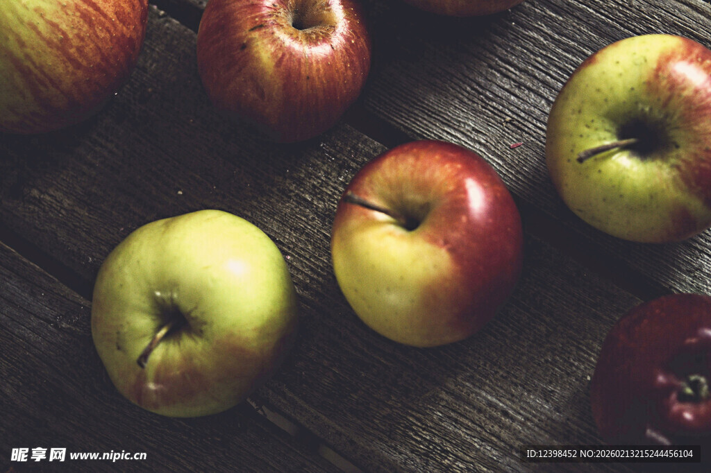 木桌上摆放的多彩苹果