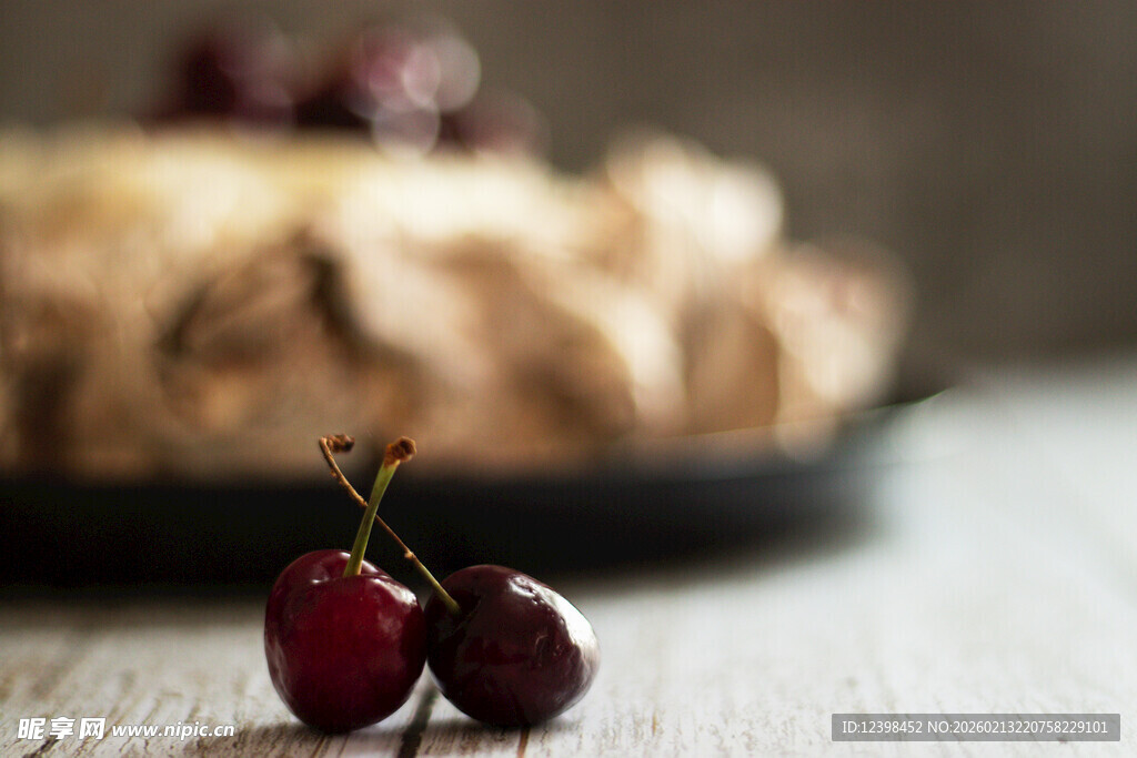 两颗鲜樱桃与背景糕点