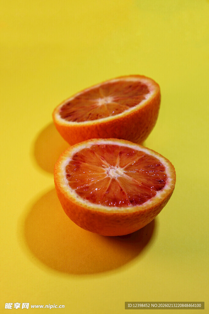两半鲜艳血橙置于黄背景