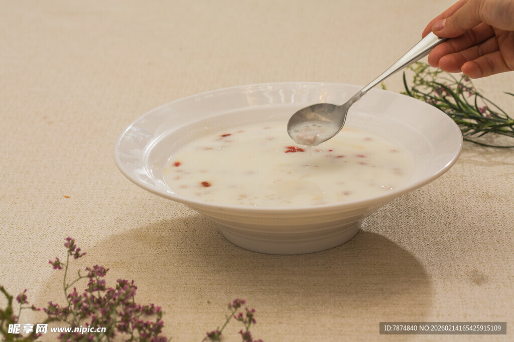 手持银勺舀起碗中美食